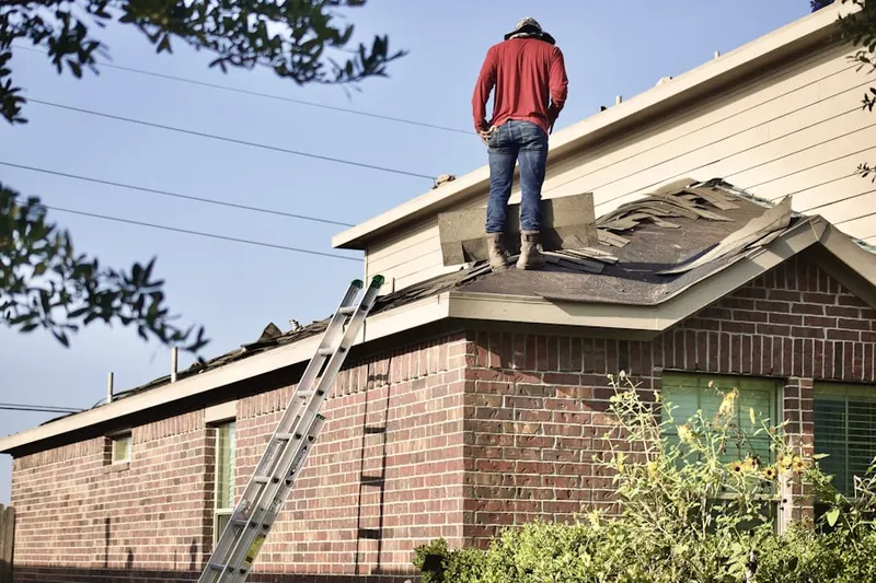 Professional roofer working on a residential roof in Bedford Four Corners
